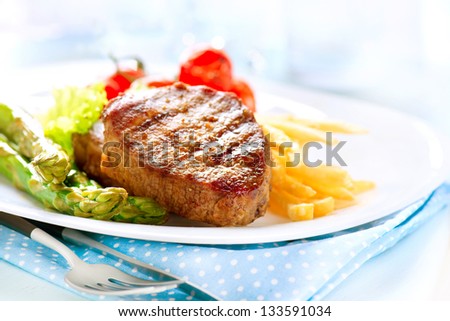 Grilled Beef Steak Meat with Fried Potato, Asparagus and Cherry Tomato. Steak Dinner. Food