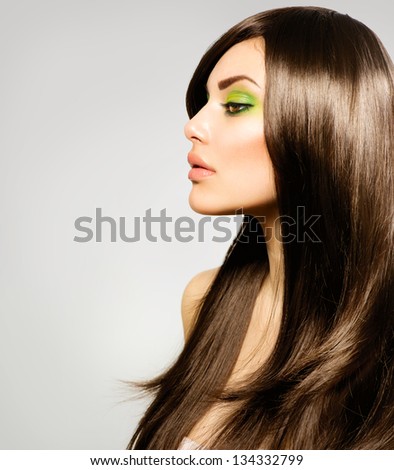Hair. Beautiful Brunette Girl. Healthy Long Brown Hair. Beauty Model Woman With Green Makeup. Trendy Spring Make-Up