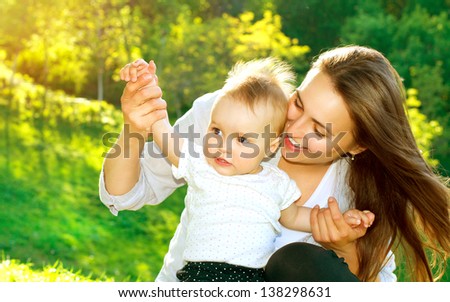 Beautiful Mother And Baby outdoors Nature Beauty Mum and her Child playing in Park Beautiful Mother And Baby outdoors Nature Beauty Mum and her Child playing in Park