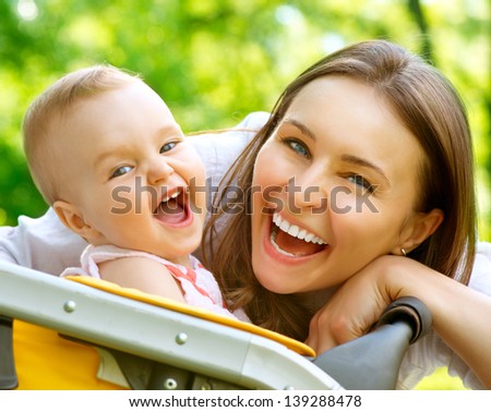 Laughing Mother And Baby Outdoors. Nature. Beauty Mum And Her Child Playing In Park Together. Outdoor Portrait Of Smiling And Happy Family. Joy. Mom And Baby