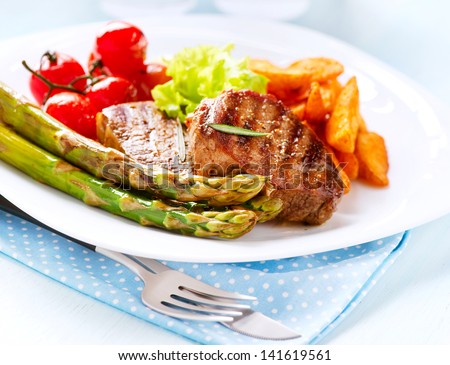 Grilled Beef Steak Meat with Fried Potato, Asparagus and Cherry Tomato. Steak Dinner. Food. BBQ Grill. Berbeque