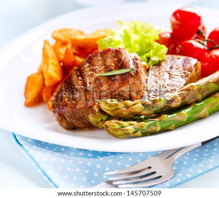 Grilled Beef Steak Meat with Fried Potato, Asparagus and Cherry Tomato. Steak Dinner. Food. BBQ Grill. Berbeque