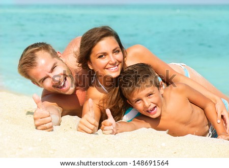 Happy Young Family With Little Kid Having Fun At The Beach. Thumbs Up. Joyful Family. Travel And Vacation. Summer Vacations