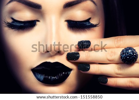 Beauty Fashion Model Girl With Black Make Up, Long Lushes. Fashion Trendy Caviar Black Manicure. Nail Art. Dark Lipstick And Nail Polish. Isolated Over Black Background