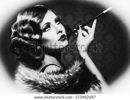 Retro Woman Portrait. Beautiful Woman with Mouthpiece. Cigarette. Smoking Lady. Vintage Styled Black and White Photo. Old Fashioned Makeup and Finger Wave Hairstyle. 20\'s or 30\'s style.