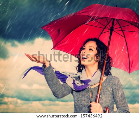 Smiling Woman with Umbrella over Autumn Rain Background. Laughing Healthy Girl outdoors. Bad Weather
