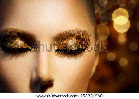 Beauty Fashion Model Girl With Holiday Leopard Makeup. Golden Wild Cat Eyes Make-Up Eyeshadow. Beautiful Woman Face With Perfect Skin. Animal Make Up