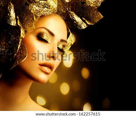 Fashion Glamour Makeup. Beauty Model Girl With Glamor Golden Make-Up And Hairstyle. Holiday Gold Makeup And Hair With Floral Design Over Black Background