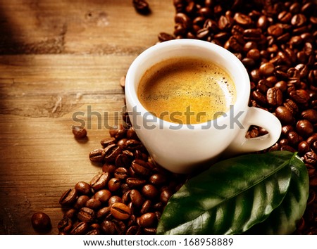 Coffee. Coffee Espresso. Cup Of Coffee with Beans and Green Leaf on a Wooden Background. Border Design