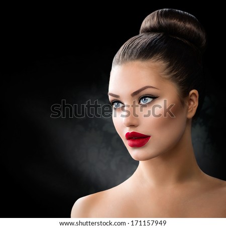 Fashion Model Girl Portrait With Blue Eyes And Full Sexy Red Lips. Creative Hairstyle. Hair Bun. Hairdo. Make Up. Beauty Woman Isolated On A Black Background