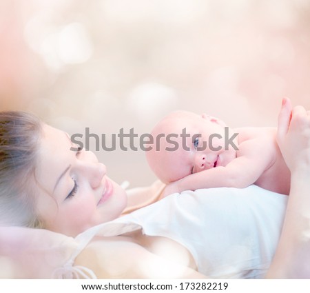 Mother And Her Newborn Baby. Happy Mother And Baby Kissing And Hugging. Resting In Bed Together. High Key Soft Image Of Beautiful Family. Maternity Concept. Parenthood. Motherhood