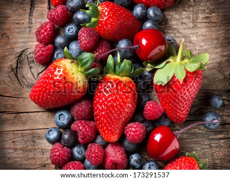 Berries on Wooden Background. Spring Organic Berry over Wood. Strawberries, Raspberries, Blueberry and Cherry. Agriculture, Gardening, Harvest Concept. Gardening. Vitamin. Diet