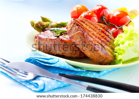 Steak. Grilled Beef Steak Meat with Vegetables - Asparagus, Cherry Tomato and Lettuce. Steak Dinner. Food