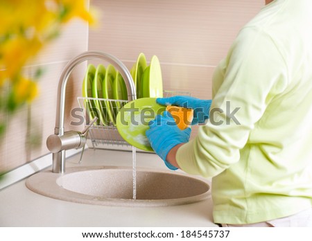 Woman Washing Dishes. Kitchen. Dishwashing. Woman doing housework at home