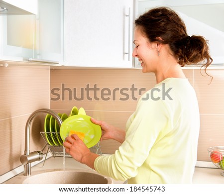 Woman Washing Dishes. Kitchen. Dishwashing. Woman doing housework at home