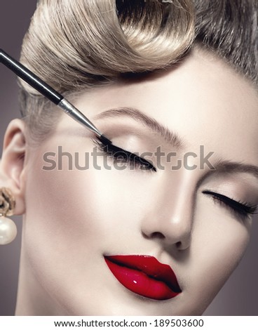 Makeup. Vintage style Make-up Applying closeup. Eyeliner. Retro styled Woman. Eyeline brush for Make up. Beauty Girl with Perfect Skin. Eyelashes. Red Lipstick. Makeover