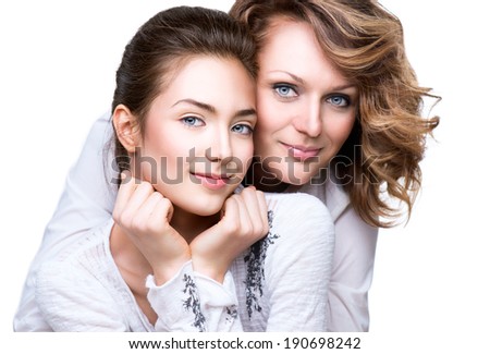 Mother and Teen Daughter. Close-up portrait of attractive happy mother and smiling teenage daughter isolated on a white background. Teenager girl with her mom