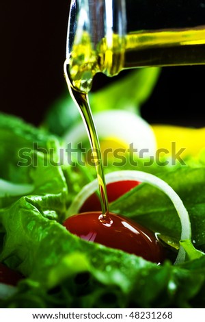 Healthy Salad and pouring olive oil closeup