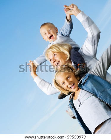 Healthy Family Outdoor.Happy Mother with Kids over blue sky