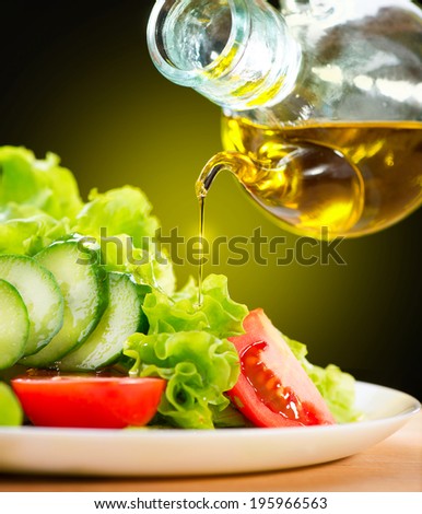 Healthy Vegetable Salad with Olive oil dressing. Pouring Olive oil. Healthy vegetarian food. Vegan. Diet, dieting concept. Lettuce, tomatoes, cucumbers. Organic bio food