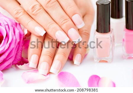 Manicure and Hands Spa. Beautiful Woman hands closeup. Manicured nails and Soft skin. Beauty hands with rose flower petals. Beauty treatment. Beautiful woman\'s nails with beautiful french manicure