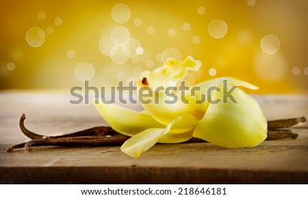 Vanilla. Pods and Flower of vanilla over Wooden Background. Vanilla Pod Stick