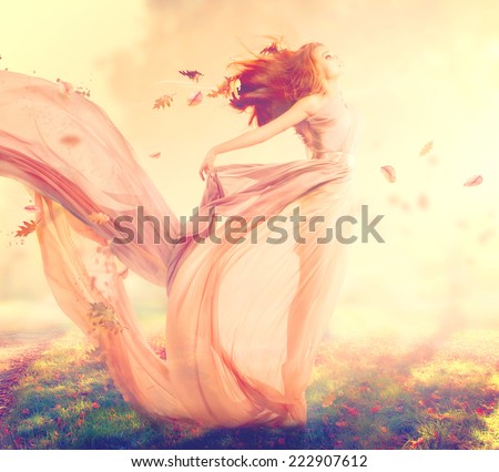 Beauty Autumn Woman, beautiful fantasy girl, fairy in blowing transparent chiffon dress. Fall. Fashion model lady in windy autumn park
