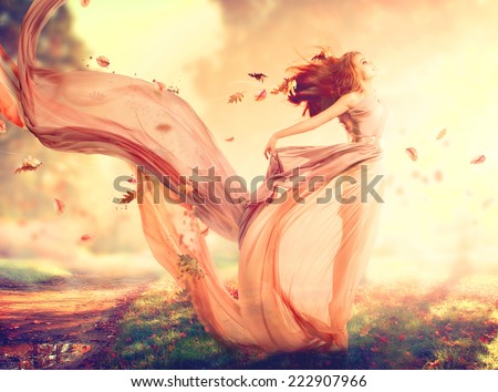 Beauty Autumn Woman, beautiful fantasy girl, fairy in blowing transparent chiffon dress. Fall. Fashion model lady in windy autumn park