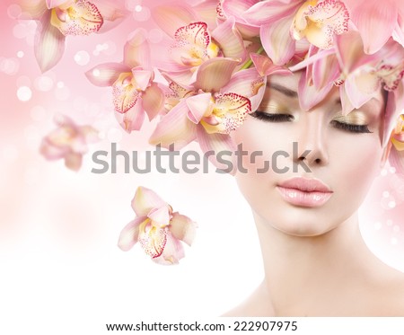 Fashion Beauty Model Girl with Orchid Flowers Hair. Spa woman. Bride. Perfect Creative Make up and Hair Style. Hairstyle. Nude makeup. Bouquet of Beautiful Flowers on lady\'s head