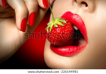 Sexy Woman Eating Strawberry. Sensual Red Lips. Red Manicure and Lipstick. Desire. Sexy red Lips with Strawberry.