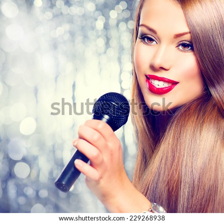 Singing Woman. Beautiful model Girl Singing. Beauty gorgeous lady with Microphone over holiday glowing Background. Singer. Karaoke song, party