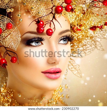 Christmas Winter Fashion Model Girl with golden hairstyle and make up. Beauty Woman. Beautiful New Year Holiday Creative Hair style decorated with holly berries. Beauty Lady face