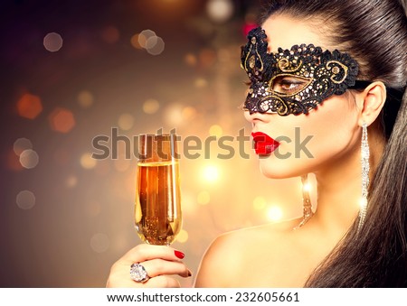 Sexy model woman with glass of champagne wearing venetian masquerade mask at party, drinking champagne over holiday glowing background. Christmas and New Year celebration