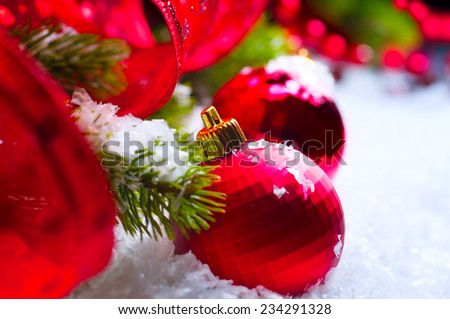 Christmas Red Baubles on snow background, Christmas and New Year Decorations, garlands and ribbon on a Christmas tree