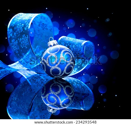 Christmas blue baubles with ribbon and stars over black background. New Year decoration art design