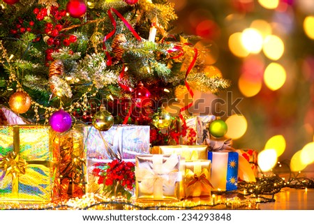 Decorated Christmas tree with various gifts. Christmas and New Year celebration. Holiday Christmas scene. Christmas gifts under the Christmas tree