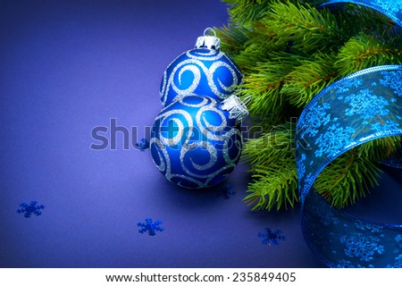 Christmas blue baubles with ribbon and snowflakes over Blue background. Xmas tree New Year decoration art design