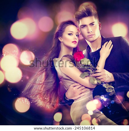 Valentine couple in love. Beauty fashion model girl with handsome model guy dancing together. Glamour couple, romantic date. Saint Valentine\'s day concept