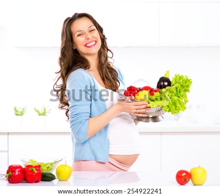 Pregnant Young Woman Cooking vegetables. Healthy Food - Vegetable Salad. Diet. Dieting Concept. Healthy Lifestyle. Cooking At Home. Prepare Food