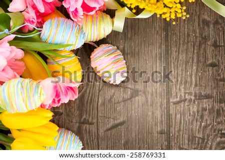 Easter Background. Beautiful Easter holiday backdrop frame decorated with colourful eggs and tulip flowers. Springtime. Invitation card design with space for your text