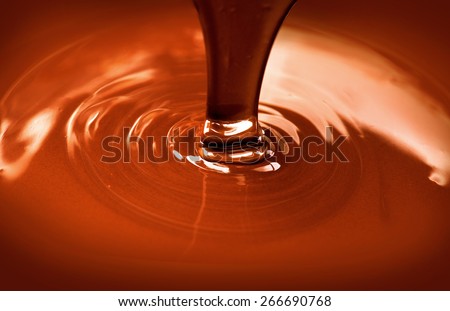 Chocolate flow. Close up of liquid hot chocolate pouring closeup. Chocolate swirl