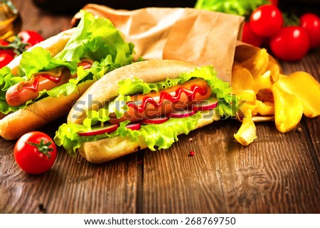 Hot dog. Grilled hot dogs with mustard and ketchup on a picnic wooden table. Sandwich