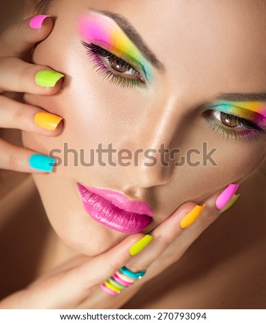 Beauty Girl face with Vivid Makeup and colorful Nail polish. Colourful nails. Fashion Woman portrait close up. Bright Colors. Long eyelashes, vivid eyeshadows Rainbow make up