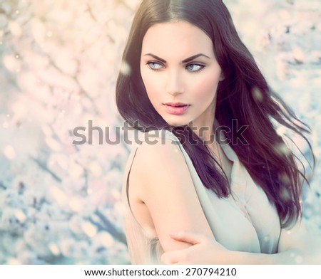 Fashion girl outdoor portrait in blooming trees. Beauty spring Romantic woman in flowers. Sensual Lady. Beautiful Woman Enjoying Nature. Romantic beauty in fantasy orchard