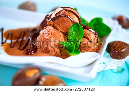 Ice cream scoops with chocolate topping. Brown chocolate icecream served with dark chocolate topping and mint