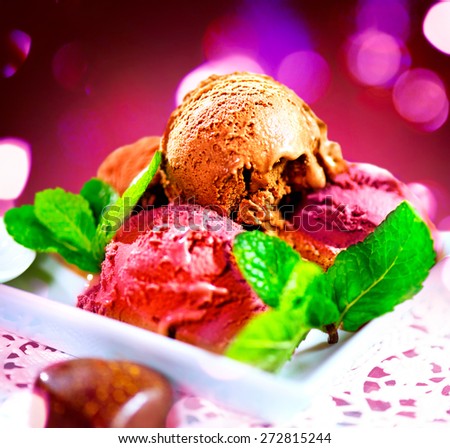 Ice cream scoops with various flavours- chocolate,fruits and berry. Brown, red and pink icecream served with dark chocolate topping and mint