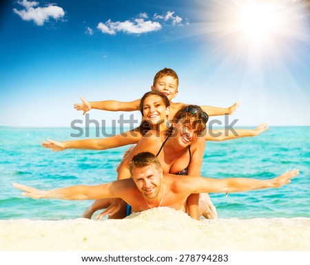 Vacation. Happy Family Having Fun at the Beach. Joyful Family. Vacation and Travel concept. Summer Holidays. Parents with Children enjoying a holiday at the sea