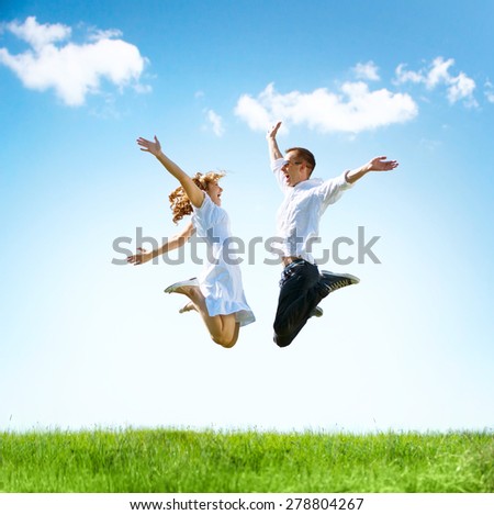 Happy Couple Outdoor. Jumping Family on Green Field. Freedom concept. Free. Jumping People. Fun