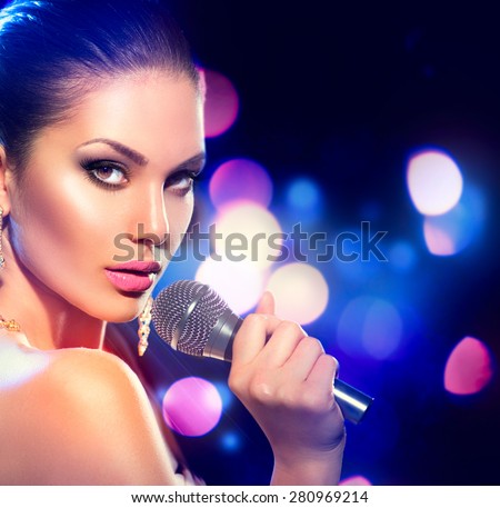 Beautiful Singing Girl. Beauty Glamour fashion Woman with Microphone over Blinking bokeh night background. Glamour Model Singer. Karaoke song. Karaoke party