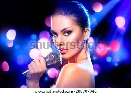 Beautiful Singing Girl. Beauty Glamor fashion Woman with Microphone over Blinking bokeh night background. Glamour Model Singer. Karaoke song. Karaoke party